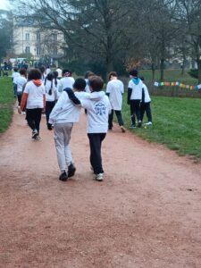 Un groupe d'enfants s'éloignent de dos sur un chemin du parc de la mairie Lyon 5. Les deux derniers se tiennent par le cou.